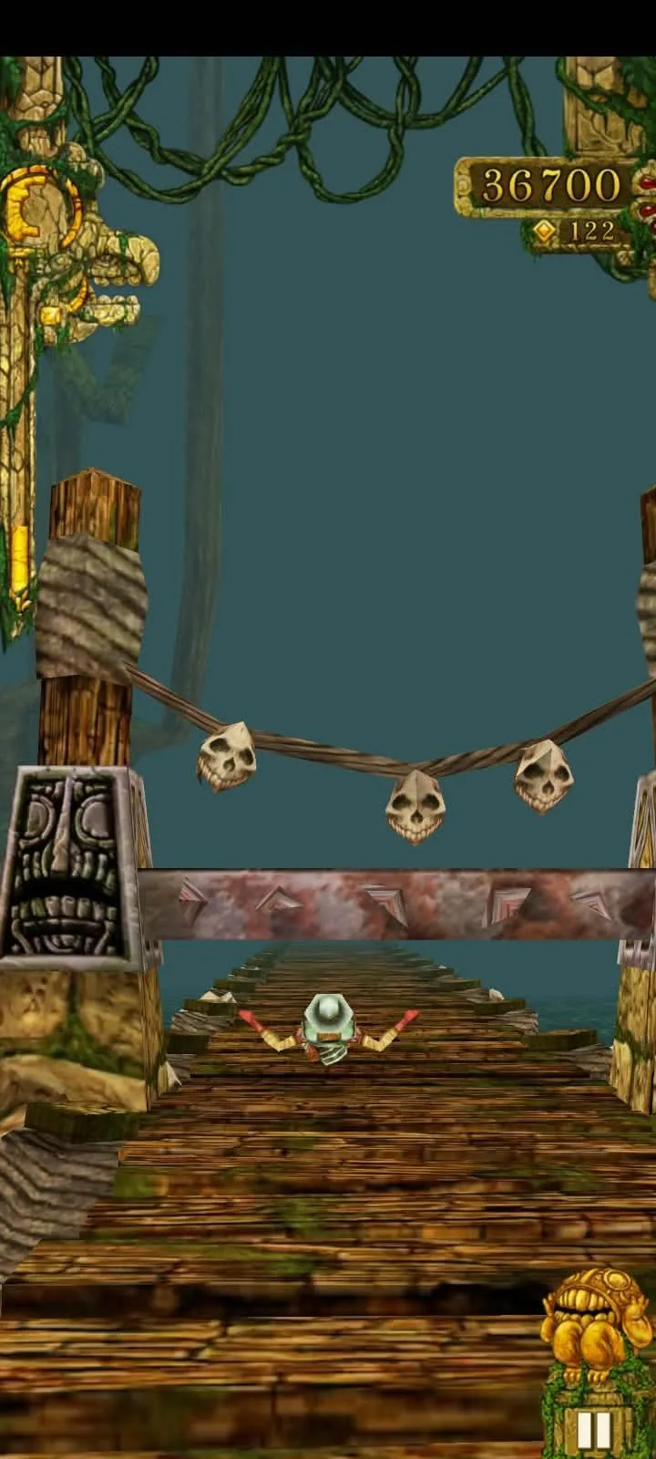 A Temple Run stretch across a wooden bridge strung with skulls, the score at 36,700